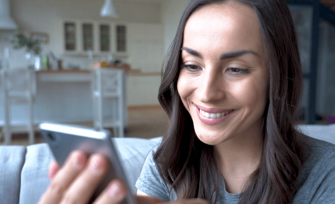 Smiling person looking at a tablet
